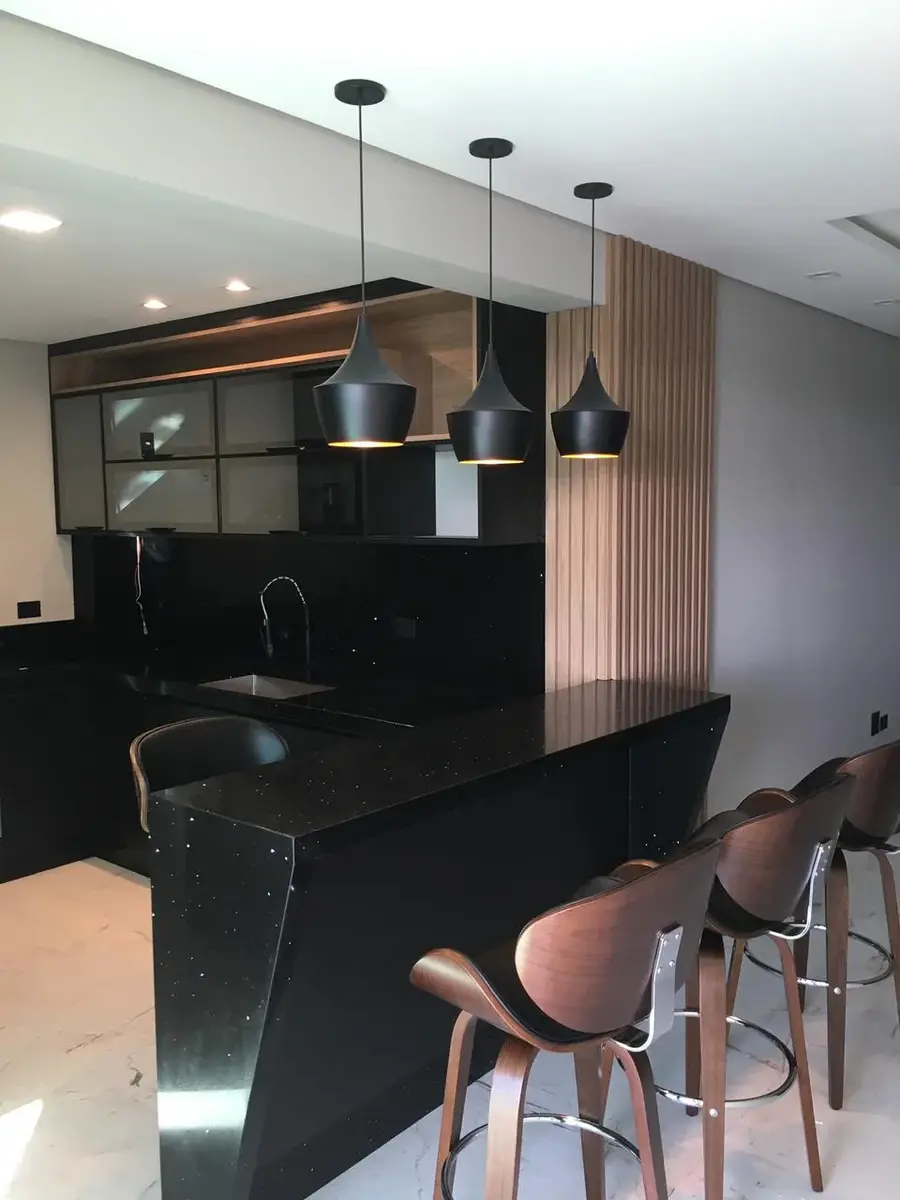 Cozinha planejada preta com balcão e pendentes