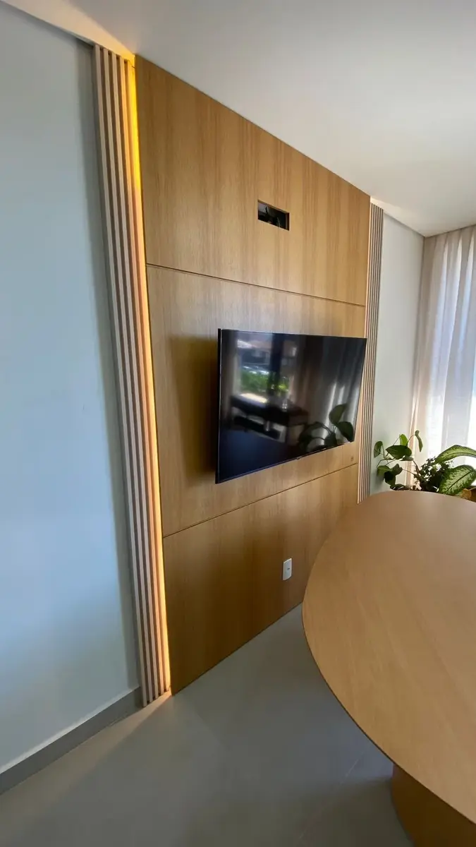 Sala de reunião com painel de madeira e mesa orgânica