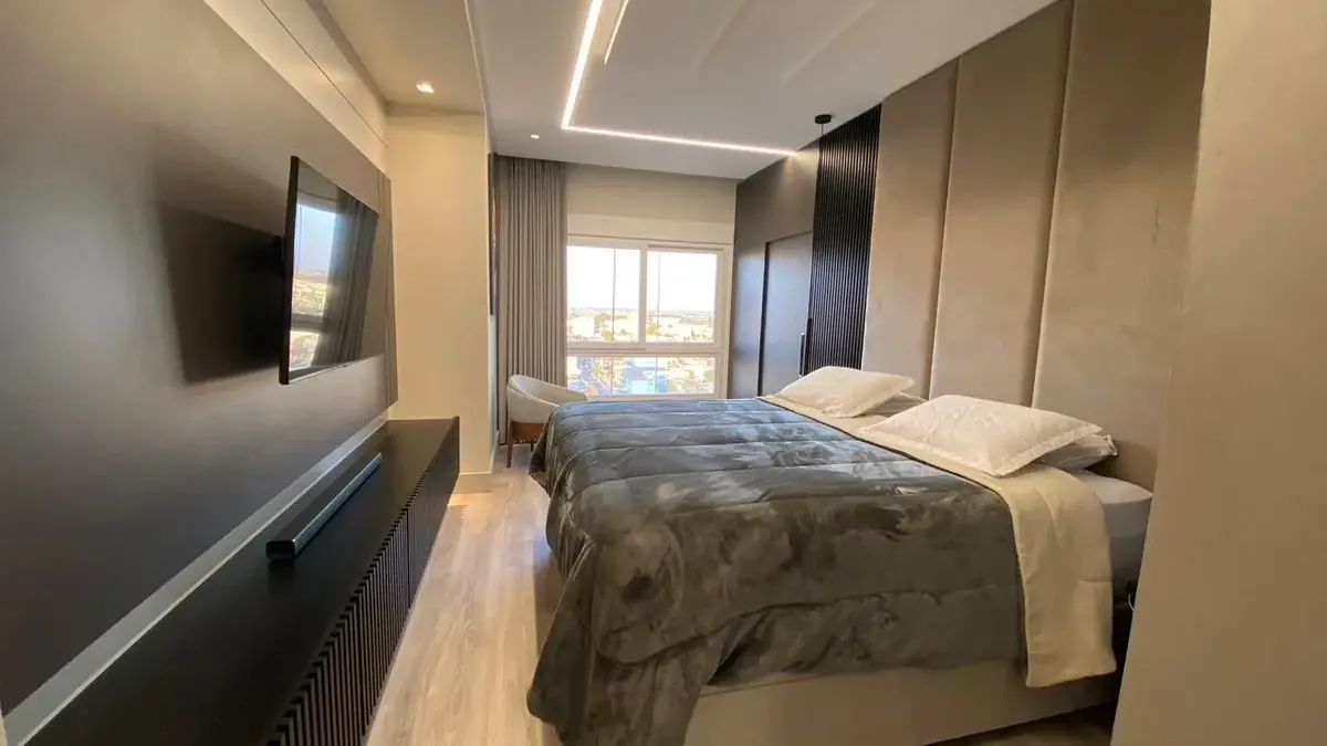 Quarto planejado com painel de cabeceira e iluminação embutida